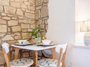 a table with two glasses of wine and two chairs at Shawdon Hill Coach House in Alnwick