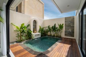 an indoor swimming pool in a house with a patio at Nidya Villa Canggu in Canggu
