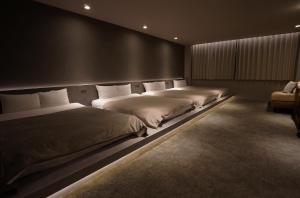 two beds in a room with ainylinylinylinylinyl at TABISAI HOTEL Luxe 博多 in Fukuoka