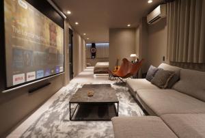 a living room with a couch and a large screen at TABISAI HOTEL Luxe 博多 in Fukuoka
