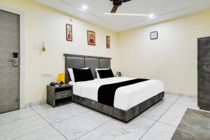 a bedroom with a black and white bed in a room at Hotel O RichFeel in Harsola +23 photos