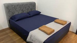 a bed in a room with two pillows on it at HOMESTAY ADELIa in Kangar