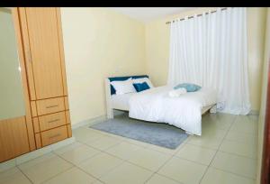 a small bedroom with a bed and a window at Cosy Nest Stays Machakos in Machakos