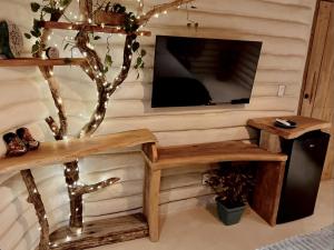 a living room with a tv and a wooden wall at Solar Kaeté - Suíte Varandas - Lençóis Maranheses in Santo Amaro