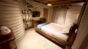 a bedroom with a bed and a tv in a room at Solar Kaeté - Suíte Varandas - Lençóis Maranheses in Santo Amaro