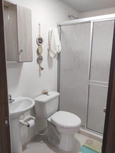 a white bathroom with a toilet and a shower at Cómodo Apartamento con parque acuático Acqua Hills-6 personas in Dosquebradas