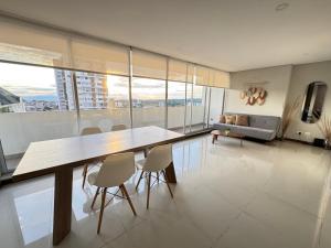 a dining room with a table and chairs and a couch at CH1204-Apartamento con linda vista en sector fundadores in Armenia