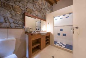Un baño con lavabo y pared de piedra. en Private Stone House, en Cannonvale 10 fotos más