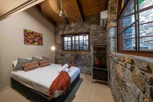 Un dormitorio con una cama en una pared de piedra. en Private Stone House, en Cannonvale