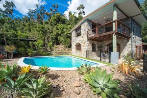 una casa con piscina delante en Private Stone House, en Cannonvale