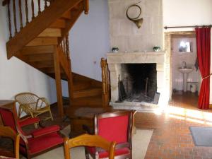 a living room with a staircase and a fireplace at château de lamberville in Lamberville