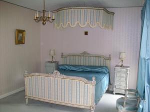 a bedroom with a bed and a chandelier at château de lamberville in Lamberville