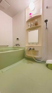 小樽Experience relaxation in Otaru's bungalow的带浴缸和带软管的水槽的浴室