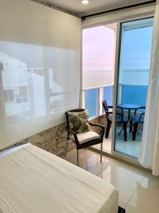 a bedroom with a bed and a chair and a table at Hospedaje,Cartagena,Clasicos,Turismocolombia-fit in Cartagena de Indias