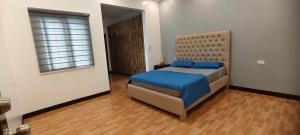 a bedroom with a bed with blue sheets and a window at M3 Private Villa in Angeles
