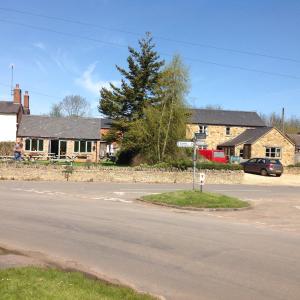 een straat met huizen en een auto op de weg bij Hops and the Vines in Shipston on Stour