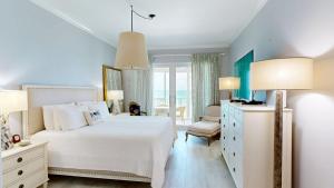 a bedroom with a white bed and a window at South Bay Beach Club #16 - 4 Bedroom 4 Bathroom Unit in George Town