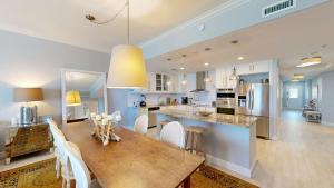 a kitchen and dining room with a wooden table and chairs at South Bay Beach Club #16 - 4 Bedroom 4 Bathroom Unit in George Town