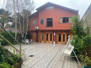 a red house with a patio in front of it at Hostal Villarrica Centro in Villarrica