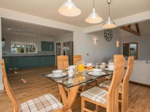 a dining room and kitchen with a table and chairs at Quarter Acre House in Challoch