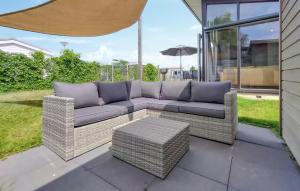 a couch sitting on a patio with an umbrella at 2 Bedroom Cozy Home In Sint-Annaland in Sint Annaland