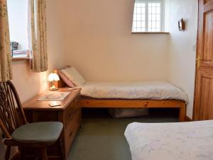 a bedroom with two beds and a desk and a chair at Marlais in Llangadog +5 photos