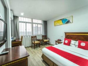 a hotel room with a large bed and a table at Nantong GuoDu Hotel in Nantong