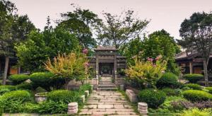 a garden with a stone path in front of a building at Xian Katie Eastman Hotel in Xi'an