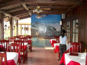 a woman walking through a dining room with red tables at Swiss Chalet in Angeles