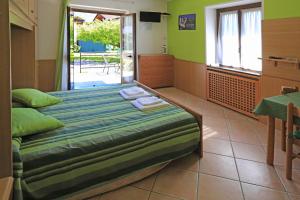 a bedroom with a bed in a room with green walls at North Wind Camping & Apartment in Domaso