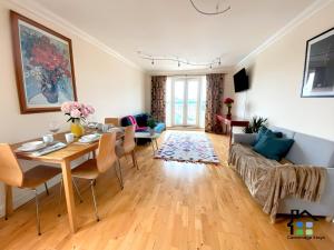 a living room with a table and a couch at CB Stays - 2 Bedroom & 2 Toilet Flat - Near Mills Road and Train Station with Parking in Cambridge