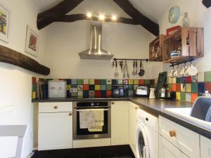 eine Küche mit Spüle und Herd in der Unterkunft Passion Flower Cottage - E1468 in Stowford