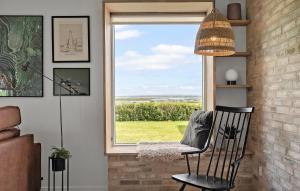a chair sitting in front of a window with a view at 3 Bedroom Cozy Home In Tarm in Tarm