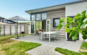 a patio with a table and chairs and an umbrella at 2 Bedroom Awesome Home In Sint-Annaland in Sint Annaland