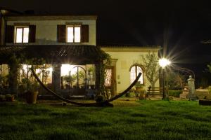 una casa con una hamaca en el patio por la noche en Cascina Vecchia Bellaria B&B en Bellaria-Igea Marina