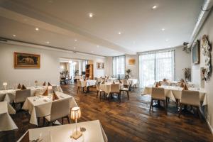 a dining room with white tables and chairs at Le Relais du Simplon in Sion