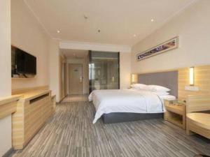 a hotel room with a bed and a flat screen tv at City Comfort Inn Zhuhai Jinwan Hangkong Xincheng in Zhuhai +85 photos