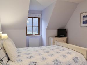 a bedroom with a bed and a window at Taigh Seonaig in Glencoe +5 photos