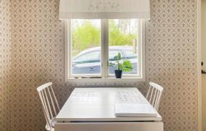 a white table and chairs in a room with a window at 3 Bedroom Nice Home In Mönsterås in Mönsterås