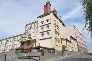 un antiguo edificio con una torre encima en Pensjonat Stary Browar, en Szubin