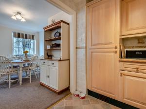 a kitchen with a table and a dining room at Tennay Cottage in Wareham