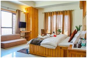 a bedroom with a large bed and a window at HOTEL THE ABHINANDAN PALACE Near Mall Road - Free Wi-Fi & Restaurant Facilities - Hygiene and Spacious Room - A Top Rated Hotel In Mussoorie in Mussoorie