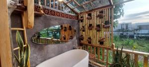 a bathroom with a mirror and a toilet on a wall at Wisnu Lumbung Uluwatu in Uluwatu