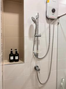 a shower in a bathroom with two bottles of soap at Elegant Getaway House in Hatyai in Ban Thung Ri