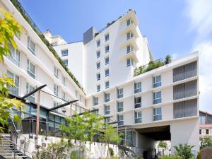 a white building with plants on the side at Hôtel Marseille Centre Gare Saint-Charles in Marseille