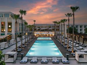 a pool with lounge chairs and palm trees in front of a building at Victoria Golf Resort and Spa Managed by Accor in Vilamoura