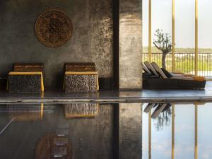 a room with chairs and a table and water at Victoria Golf Resort and Spa Managed by Accor in Vilamoura