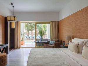 a bedroom with a large bed and a living room at Victoria Golf Resort and Spa Managed by Accor in Vilamoura