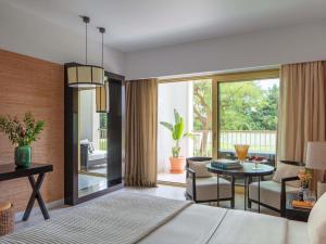 a bedroom with a bed and a living room with a table at Victoria Golf Resort and Spa Managed by Accor in Vilamoura