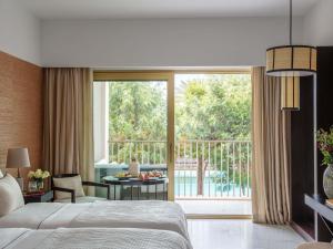 a bedroom with a bed and a view of a balcony at Victoria Golf Resort and Spa Managed by Accor in Vilamoura